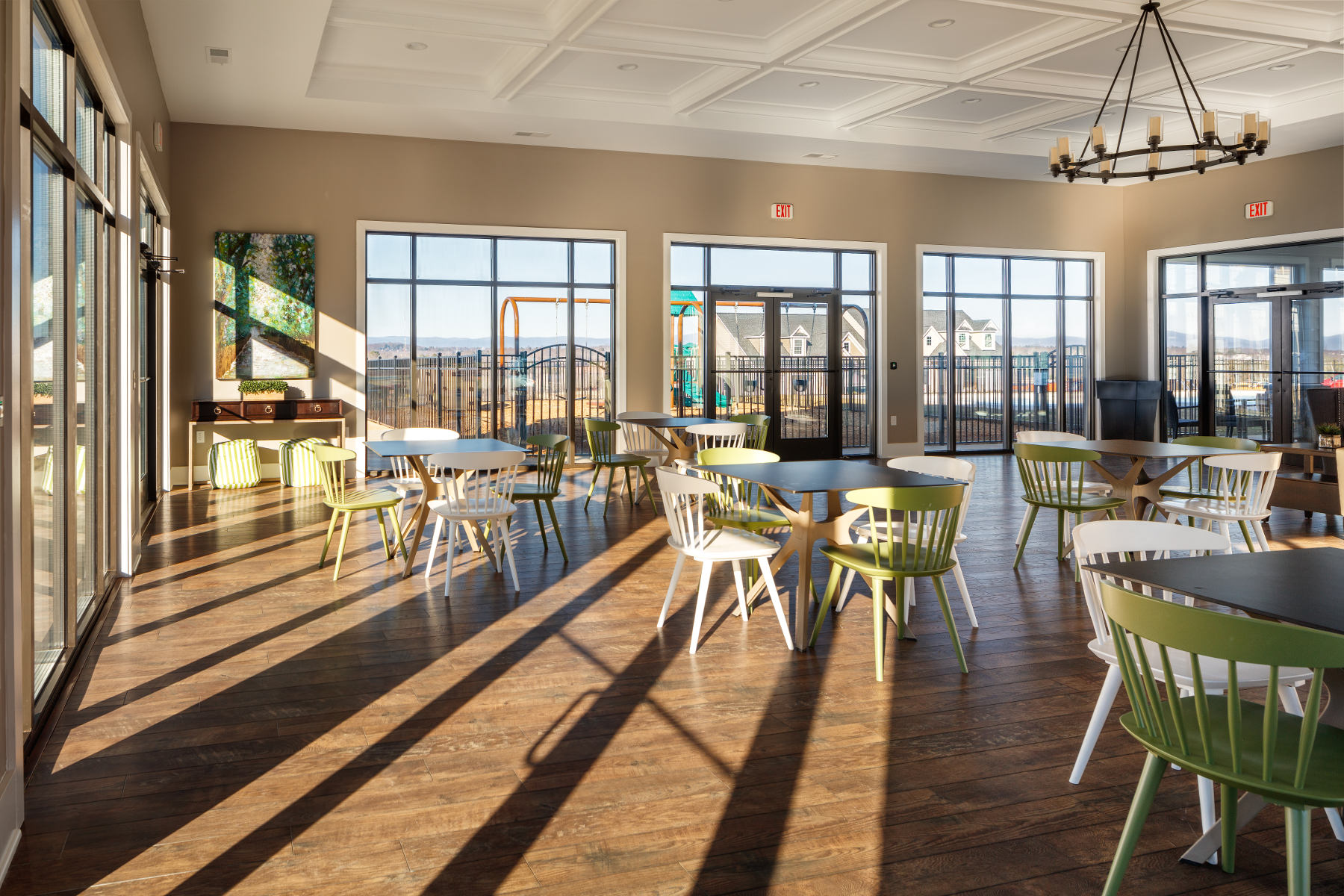 Cascadia clubhouse interior dining area with view of the playground through the windows.